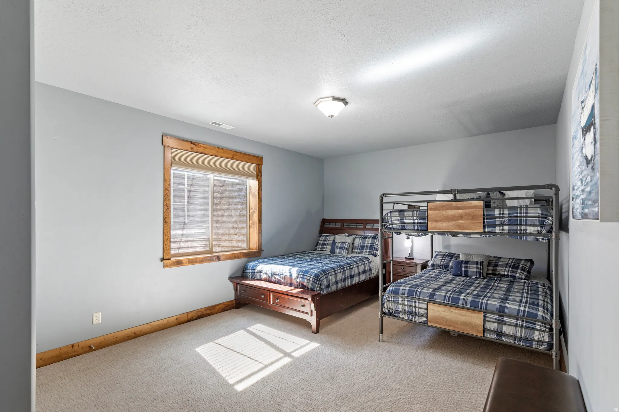 Carpeted room with a single window featuring wood trim