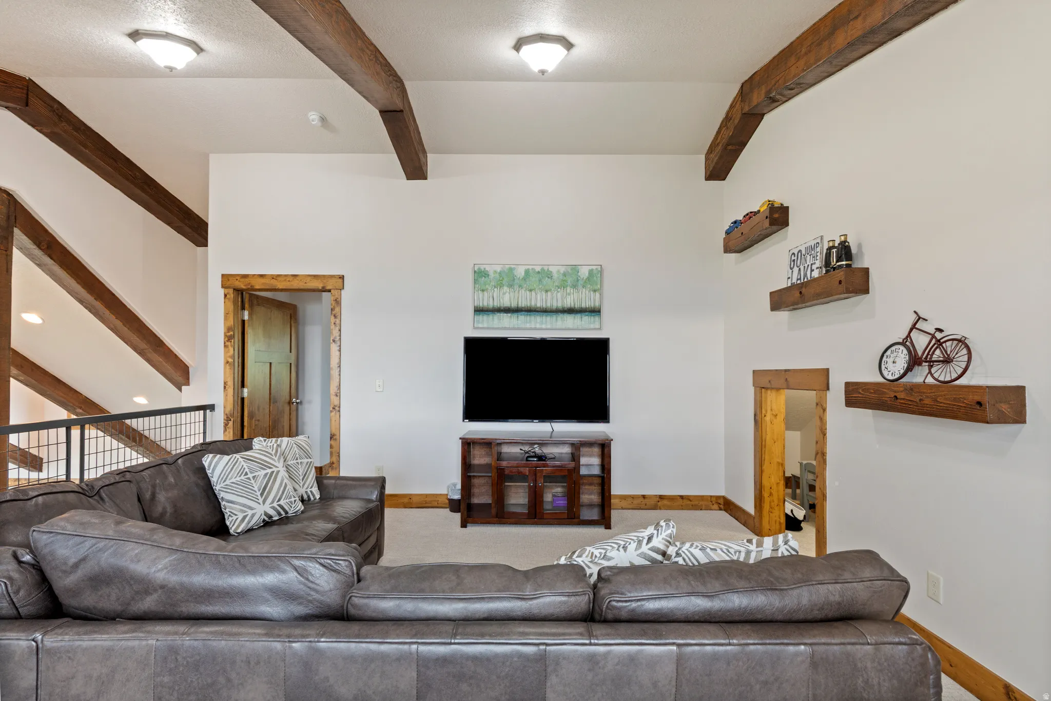 Living area with vaulted ceilings, exposed wood beams, and recessed lighting