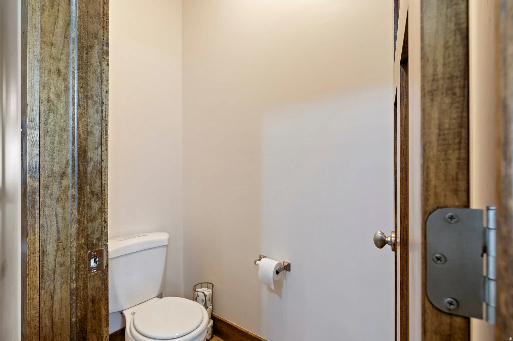 Recessed toilet alcove with light-toned walls and wood-finish door frames