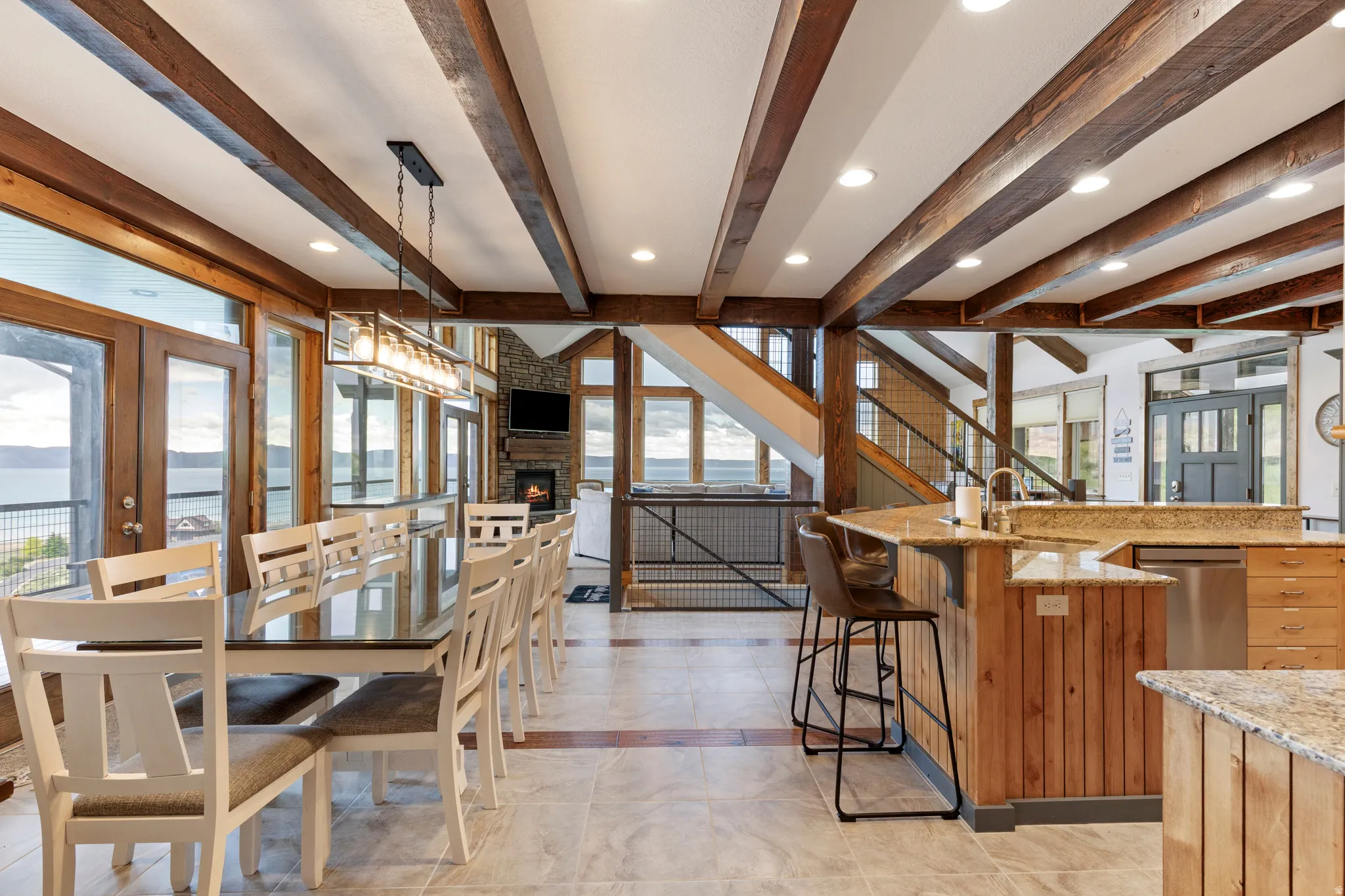 Open-concept living area with exposed wood beams and recessed lighting