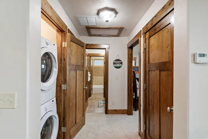 Hallway featuring wood-finish doors and trim, carpeted flooring, and a recessed lighting fixture