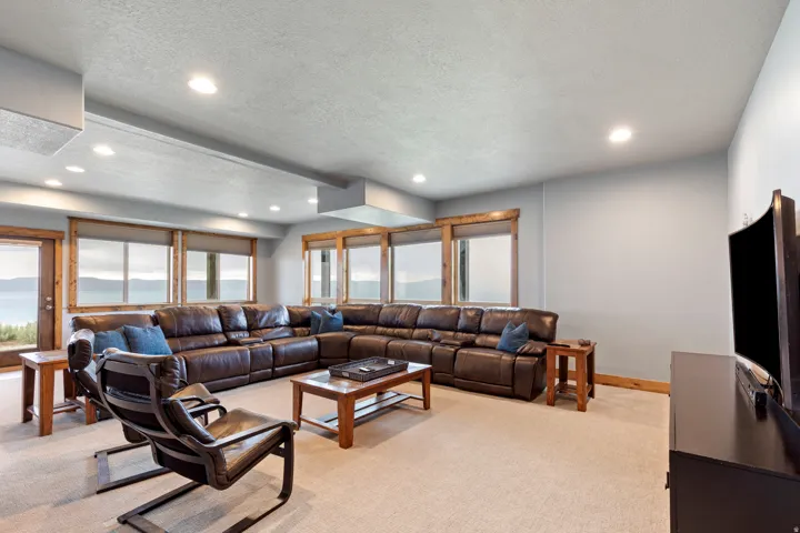 Spacious living area featuring light-toned carpeting and recessed lighting