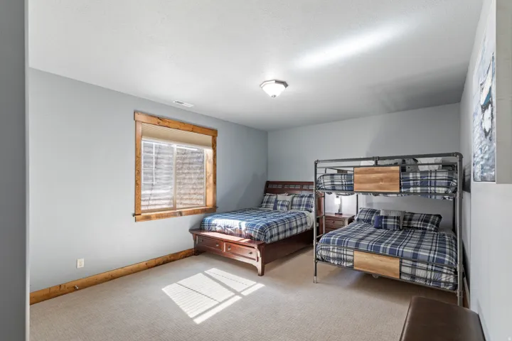 Carpeted room with a single window featuring wood trim