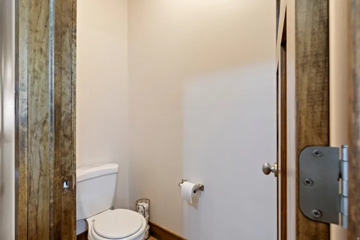Recessed toilet alcove with light-toned walls and wood-finish door frames