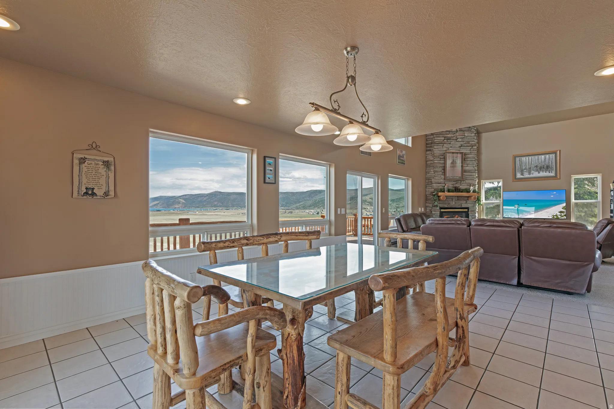 Open-concept living space featuring a dining area with tile flooring and a multi-light chandelier