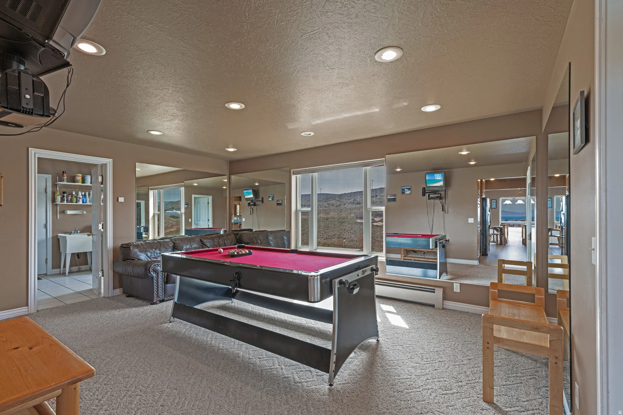 Recessed lighting illuminates a carpeted recreation area featuring a pool table