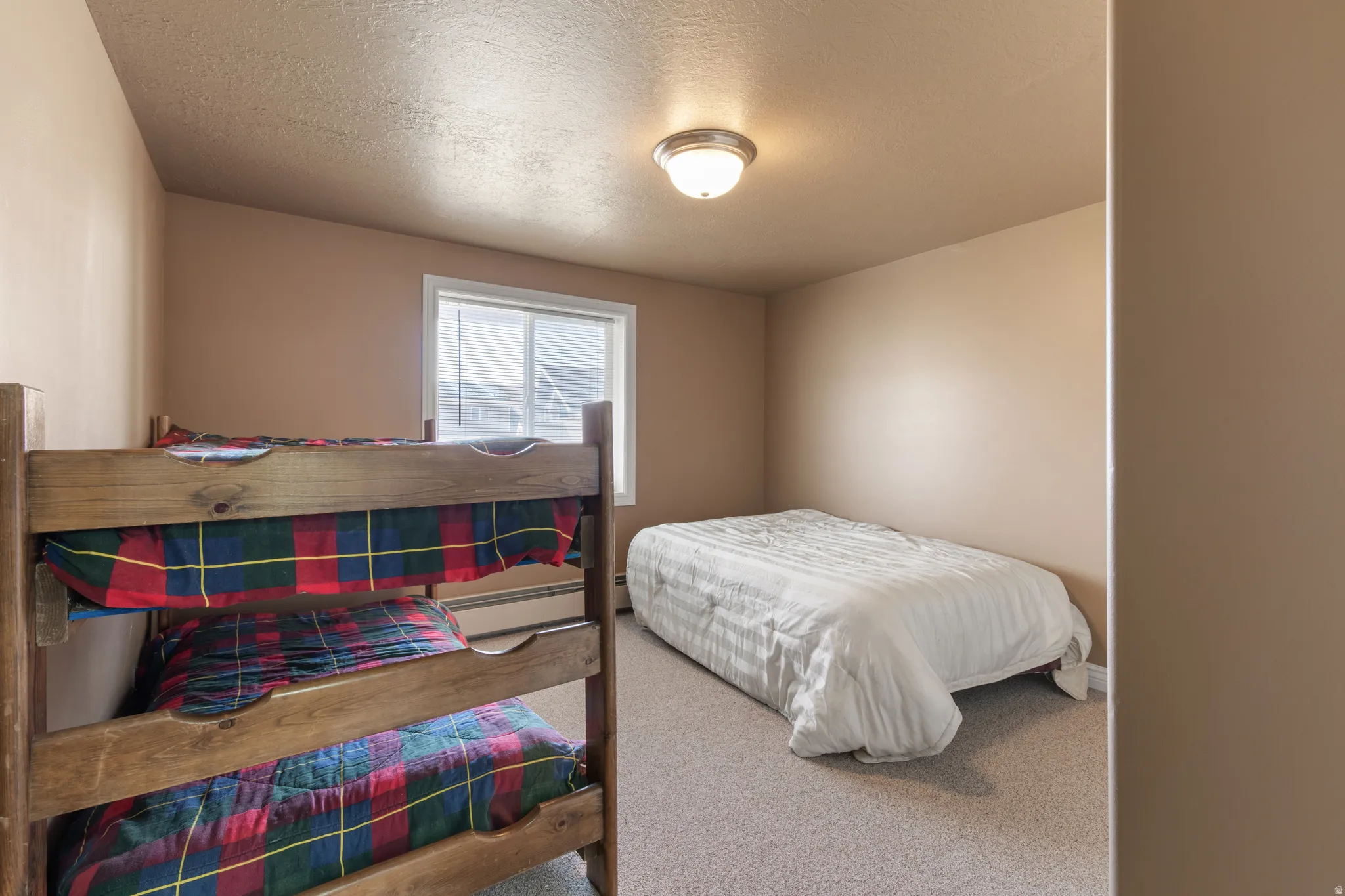 Carpeted room with a single window and neutral wall tones