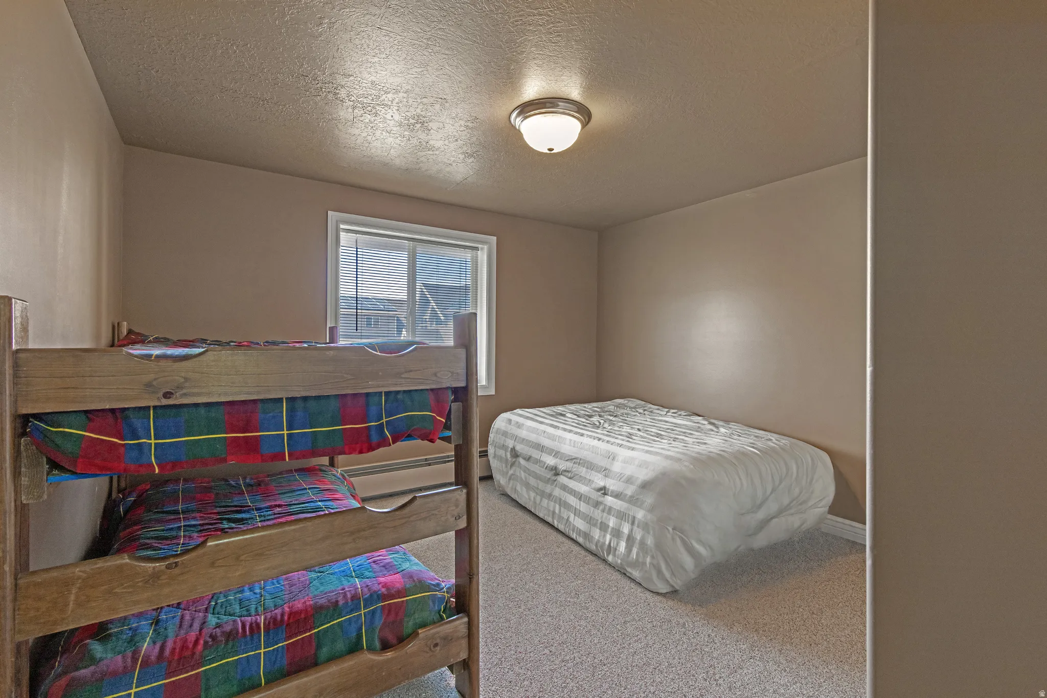 Room featuring light brown walls and neutral-toned carpeting