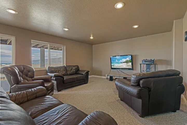 Expansive recreation room featuring recessed lighting, a neutral wall palette, and carpeted flooring