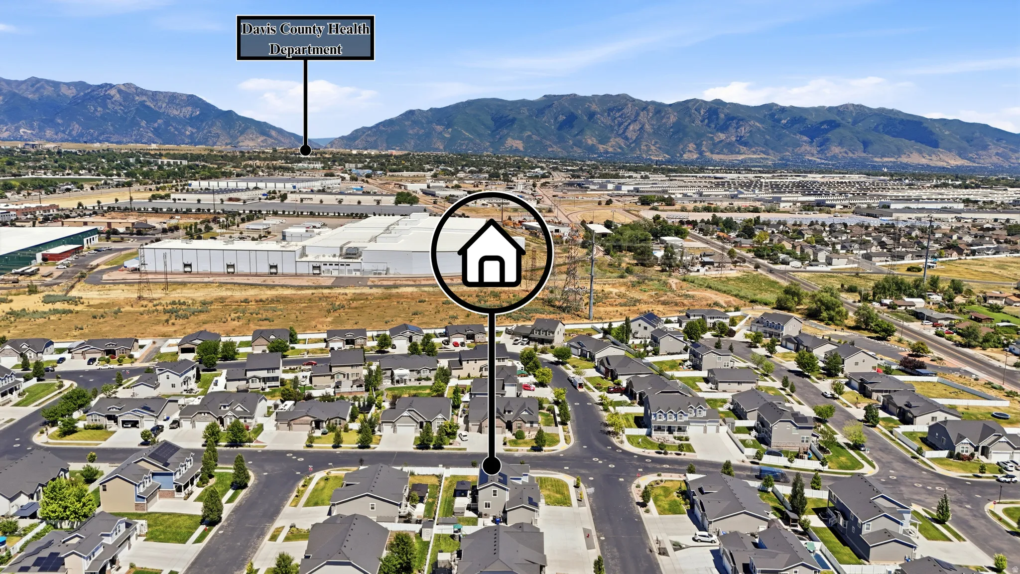Residential neighborhood featuring a grid of paved streets and sidewalks, with mountains forming the background
