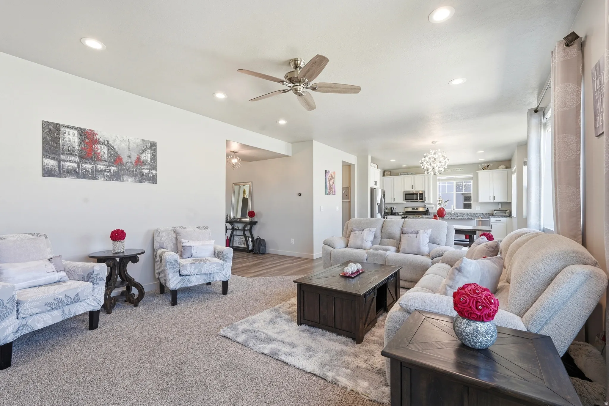 Open-concept living area featuring recessed lighting, a ceiling fan, and light-toned carpet