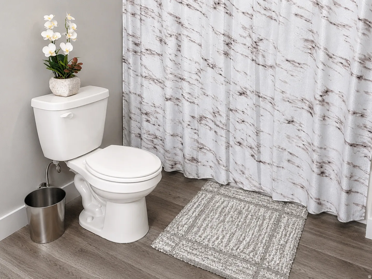 Bathroom featuring wood-finish flooring, a white toilet, and a tub/shower