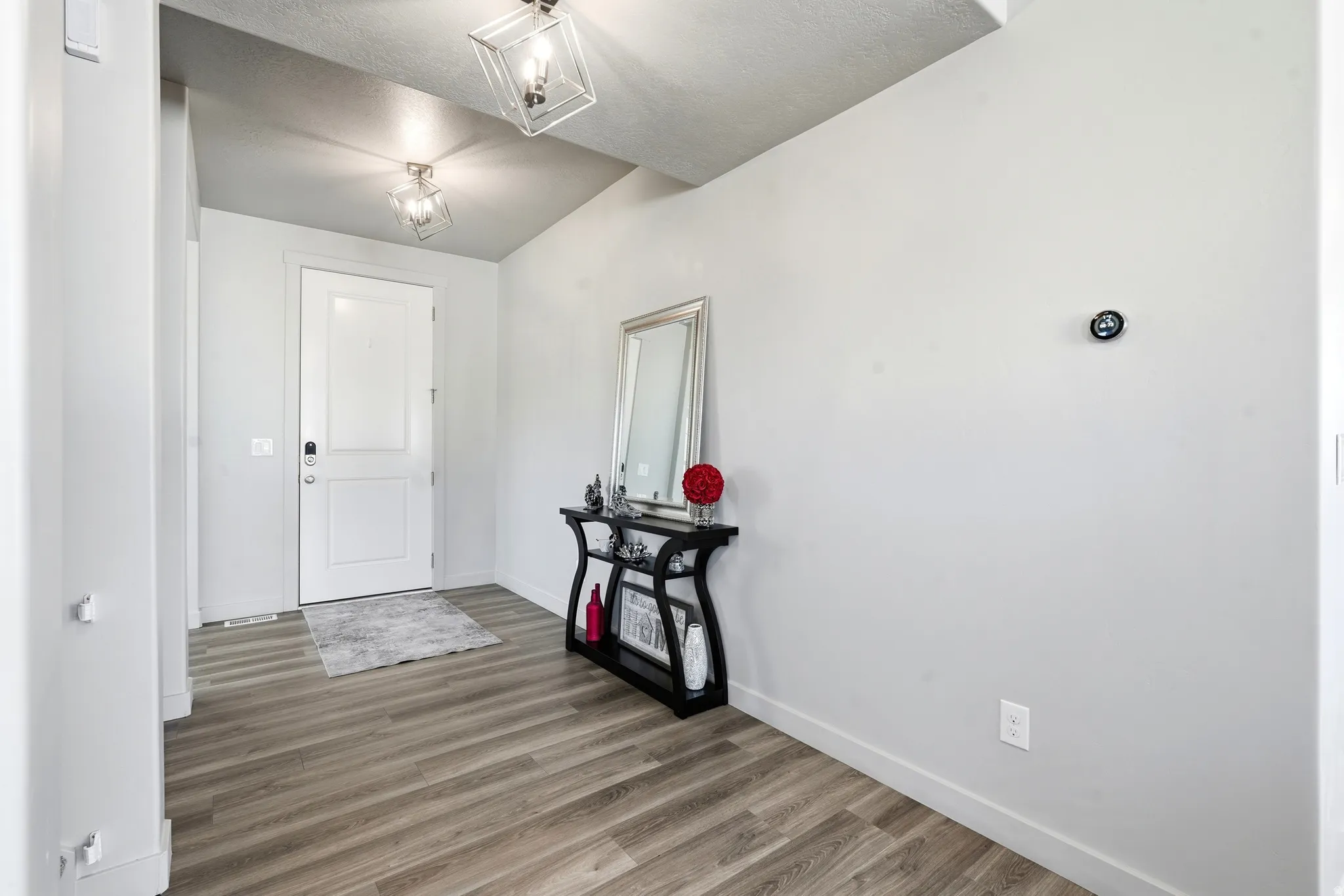 Entryway featuring wood-finish flooring and two contemporary ceiling light fixtures