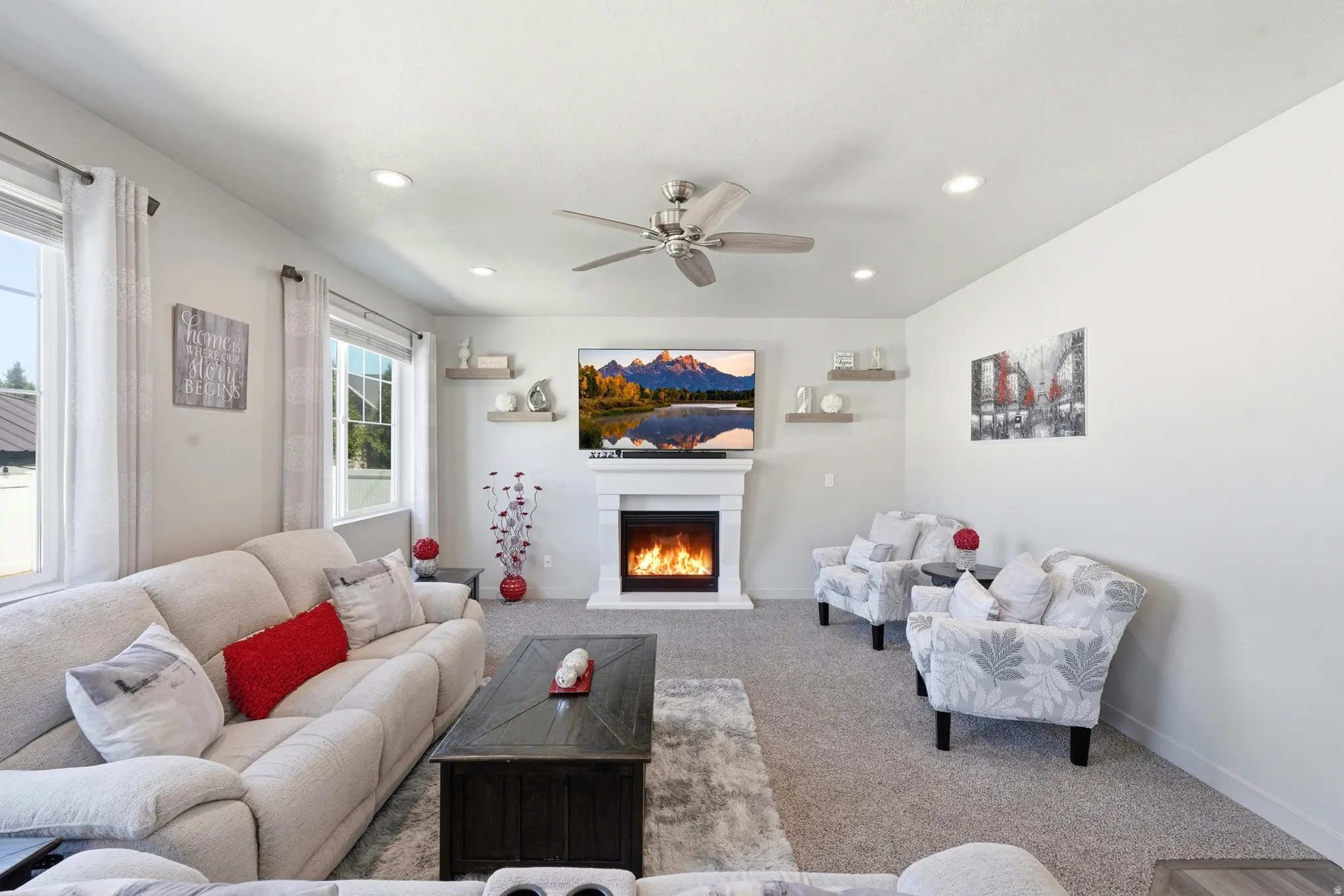 Living area featuring a fireplace with a white mantel, recessed lighting, and a ceiling fan