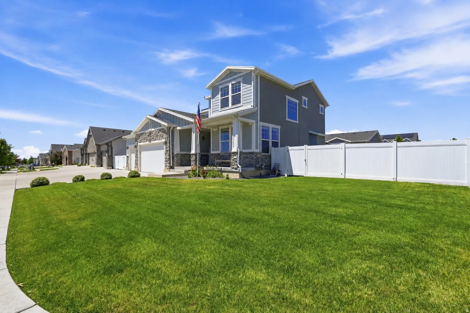 Modern two-story residence featuring light gray siding and stone facade accents
