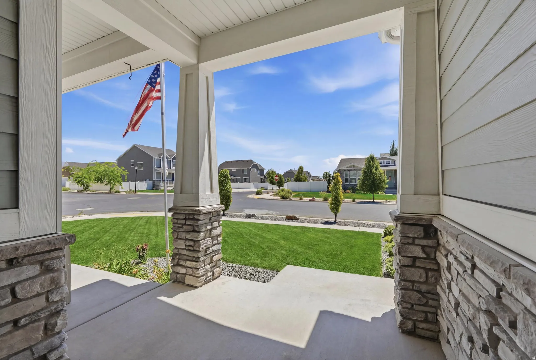 Inviting covered porch with stone-clad columns and a v-groove ceiling