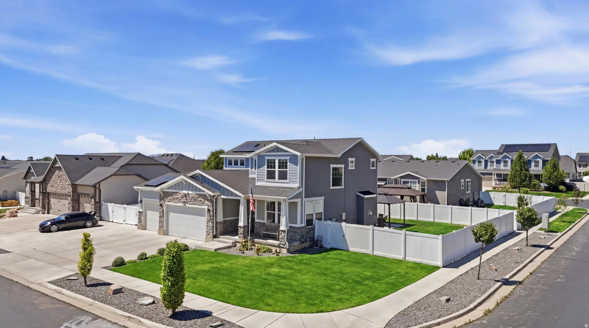 Two-story residence featuring a covered front porch, stone veneer accents, and a two-car garage