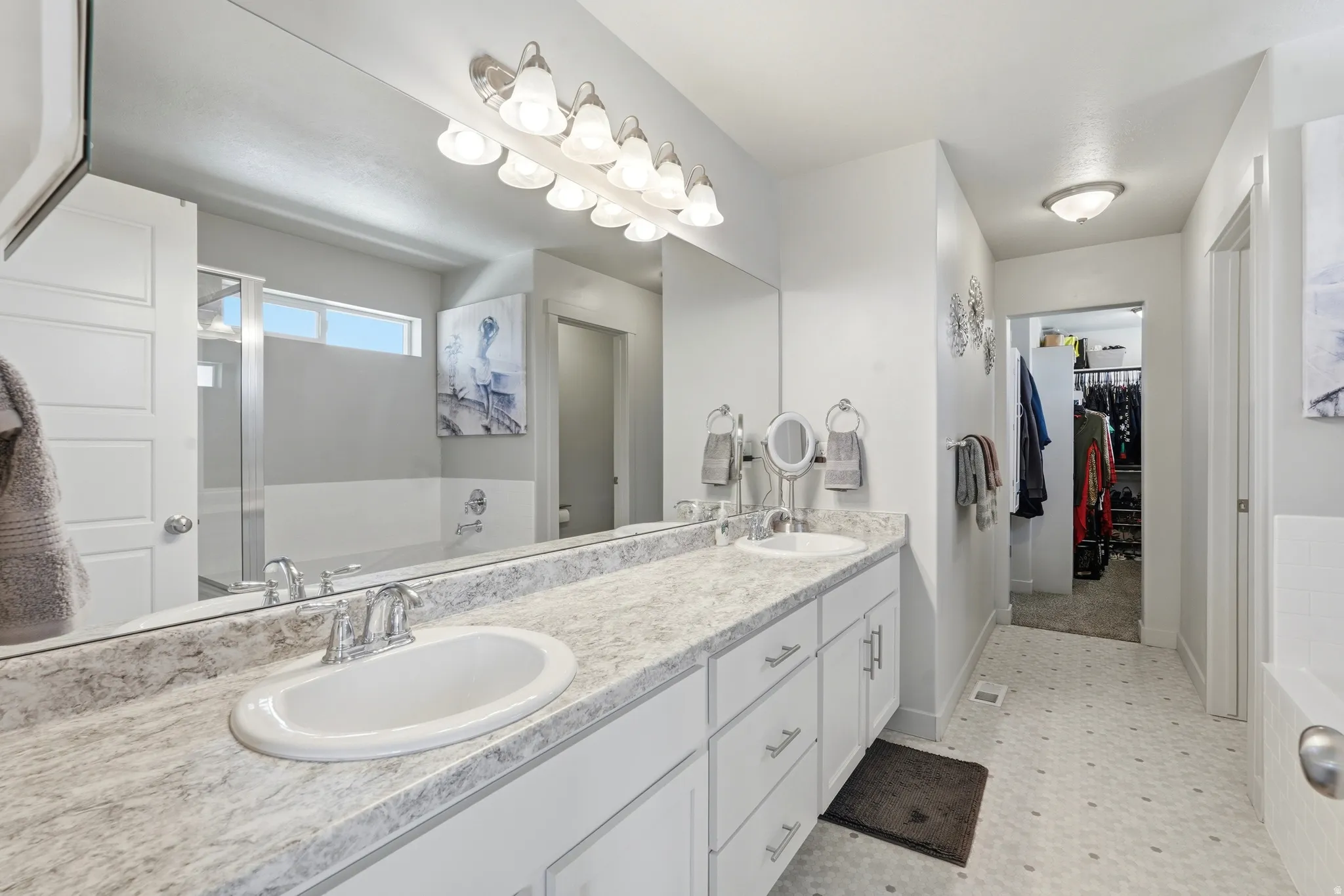 Dual vanity with undermount sinks, chrome fixtures, and a light-toned countertop