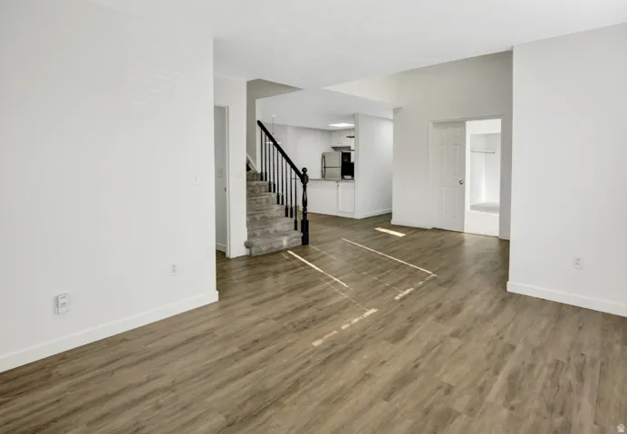 Open-concept living space featuring wood-finish flooring and bright white walls