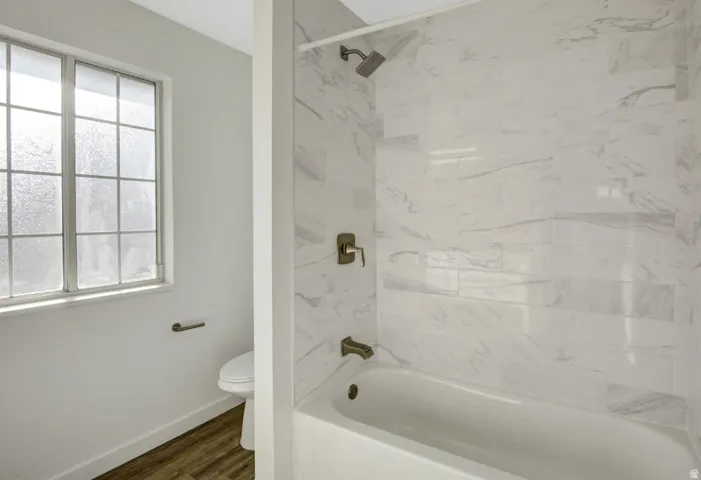 Bathtub with tile surround, bronze fixtures, and showerhead