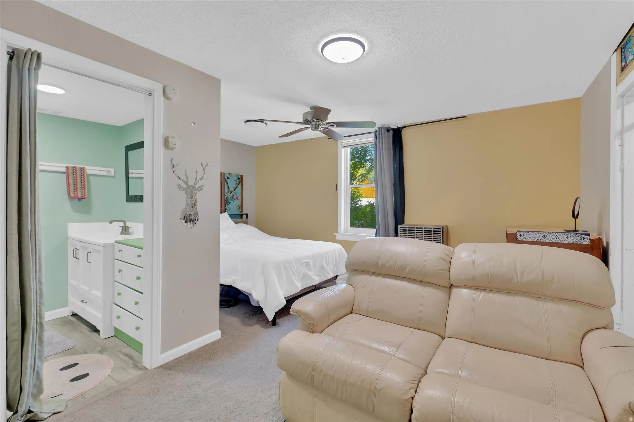 Room featuring a ceiling fan with integrated lighting, a window with exterior views, and neutral-toned wall finishes