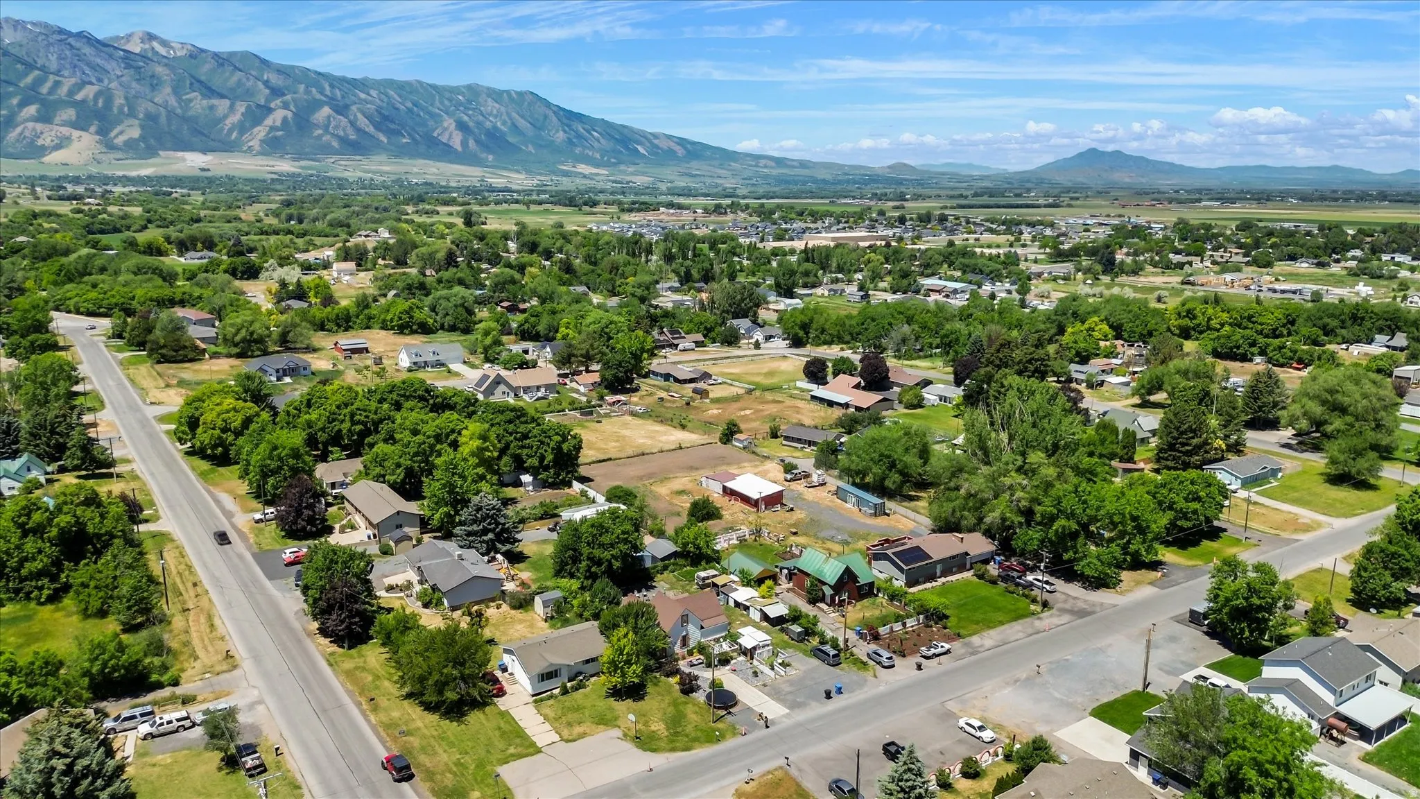 Expansive residential area featuring established homes, mature trees, and mountainous terrain