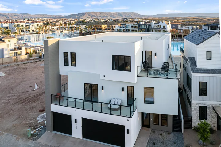 Modern multi-level exterior with crisp white stucco and black-framed windows