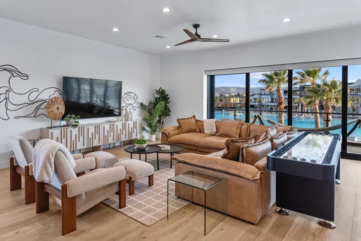 Living area featuring wood-finish flooring, a contemporary ceiling fan, and recessed lighting