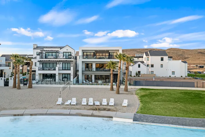 Modern residential architecture with multiple balconies, expansive glass doors, and a neutral exterior palette