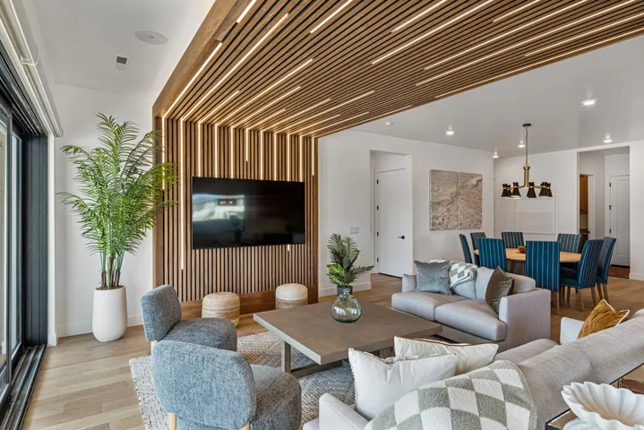 Open-concept living area featuring wood-finish flooring and a wood-slat ceiling with integrated lighting