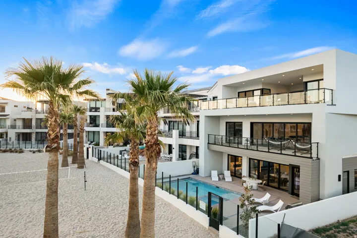 Modern multi-level exterior with crisp white stucco and dark framed windows