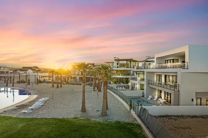 Modern multi-story residences featuring expansive balconies with glass railings