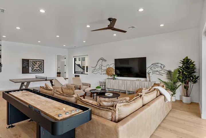 Spacious room with wood-finish flooring, recessed lighting, and a ceiling fan