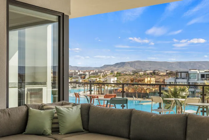 Balcony with glass railing overlooking a large pool area