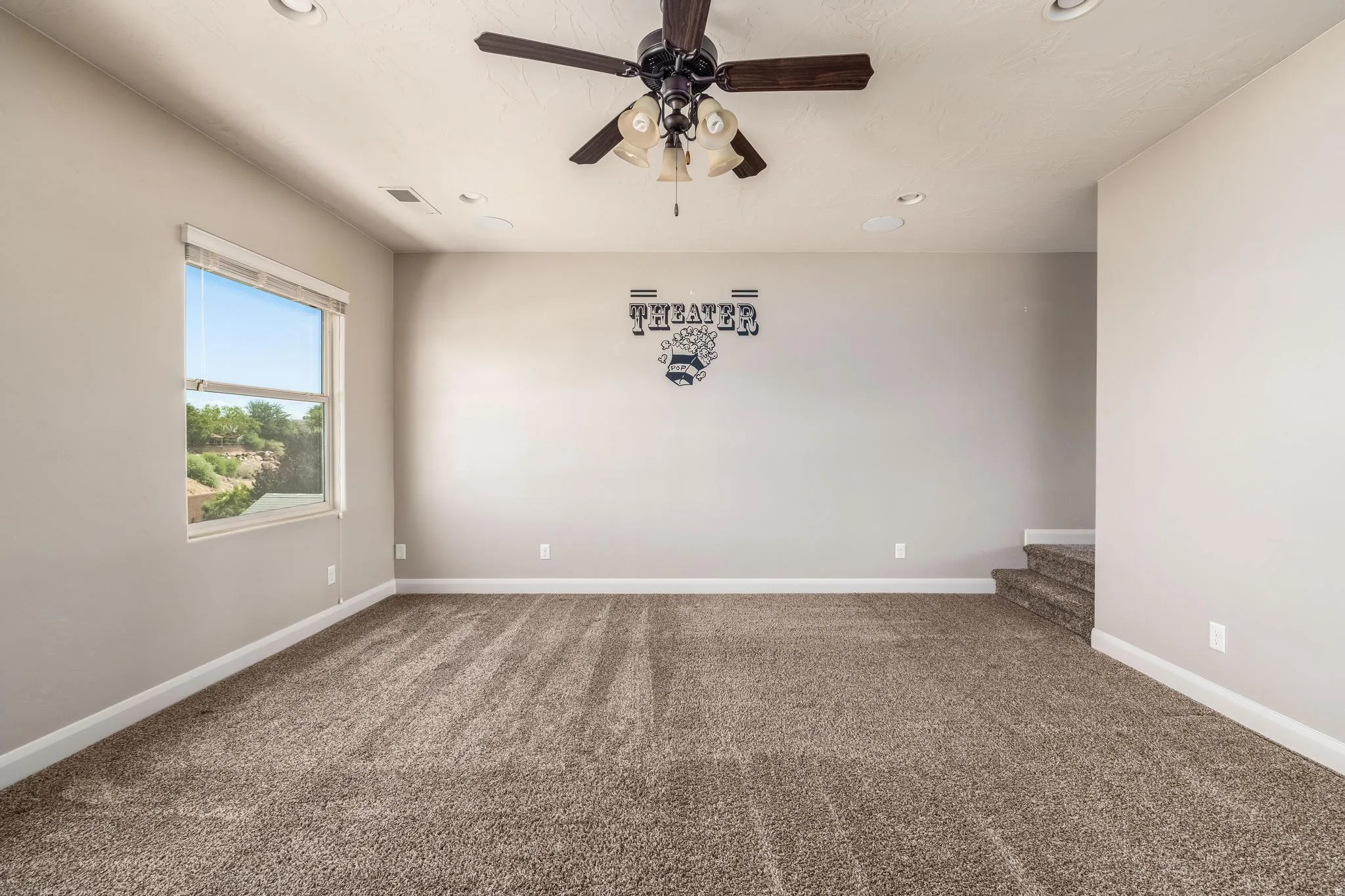 Spacious room featuring neutral carpeting and light gray walls