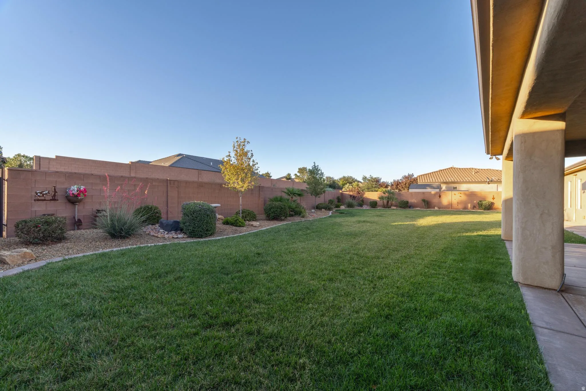 Expansive grass lawn bordered by a block wall and desert landscaping