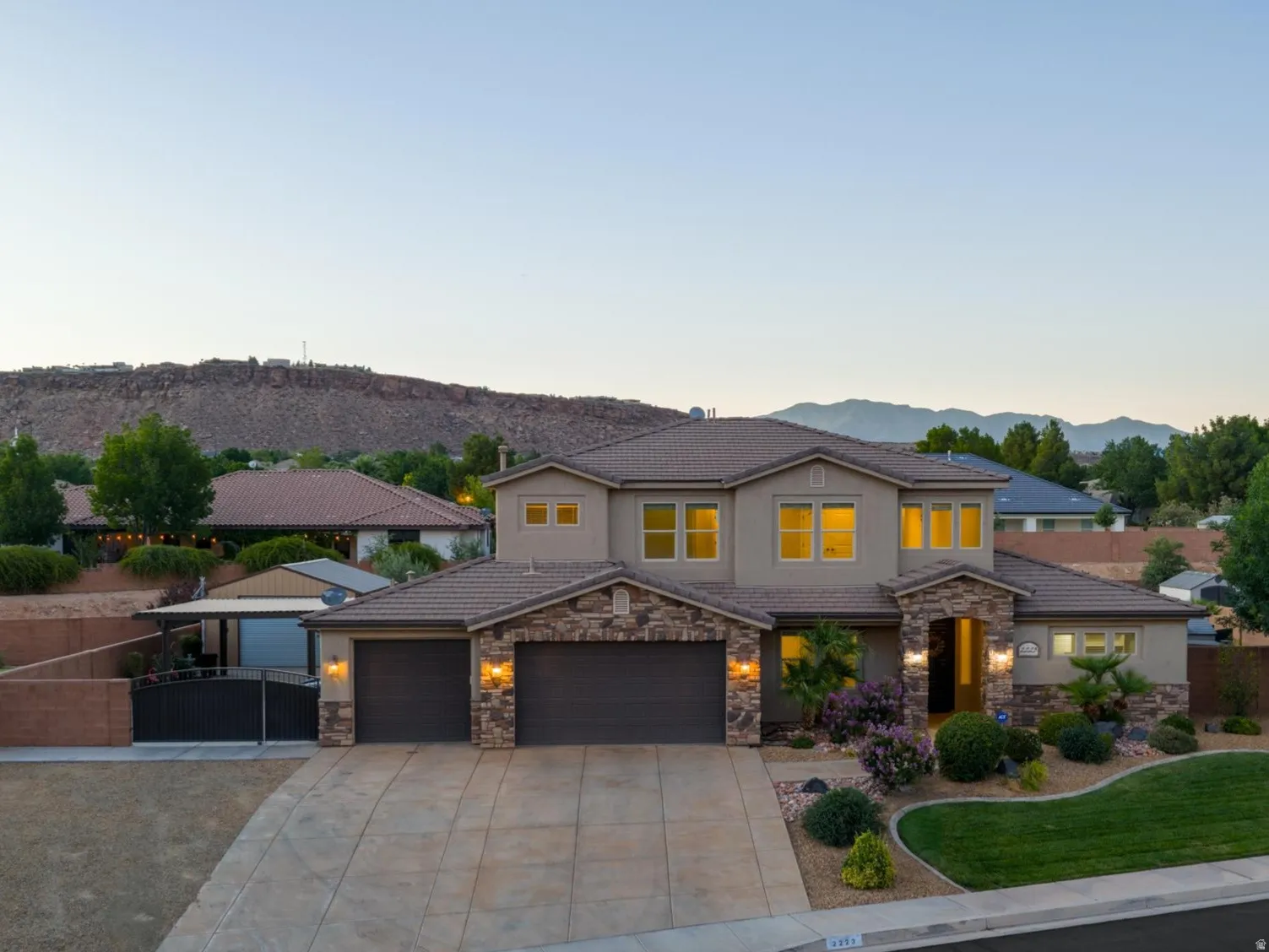 Two-story residence featuring a stone and stucco exterior, an attached three-car garage, and a concrete driveway