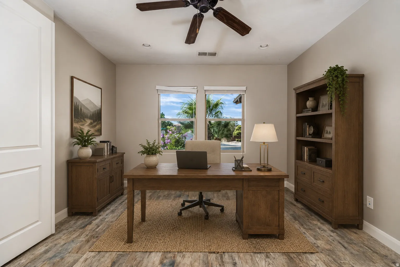 Spacious interior room featuring wood-finish flooring, neutral wall tones, and a ceiling fan
