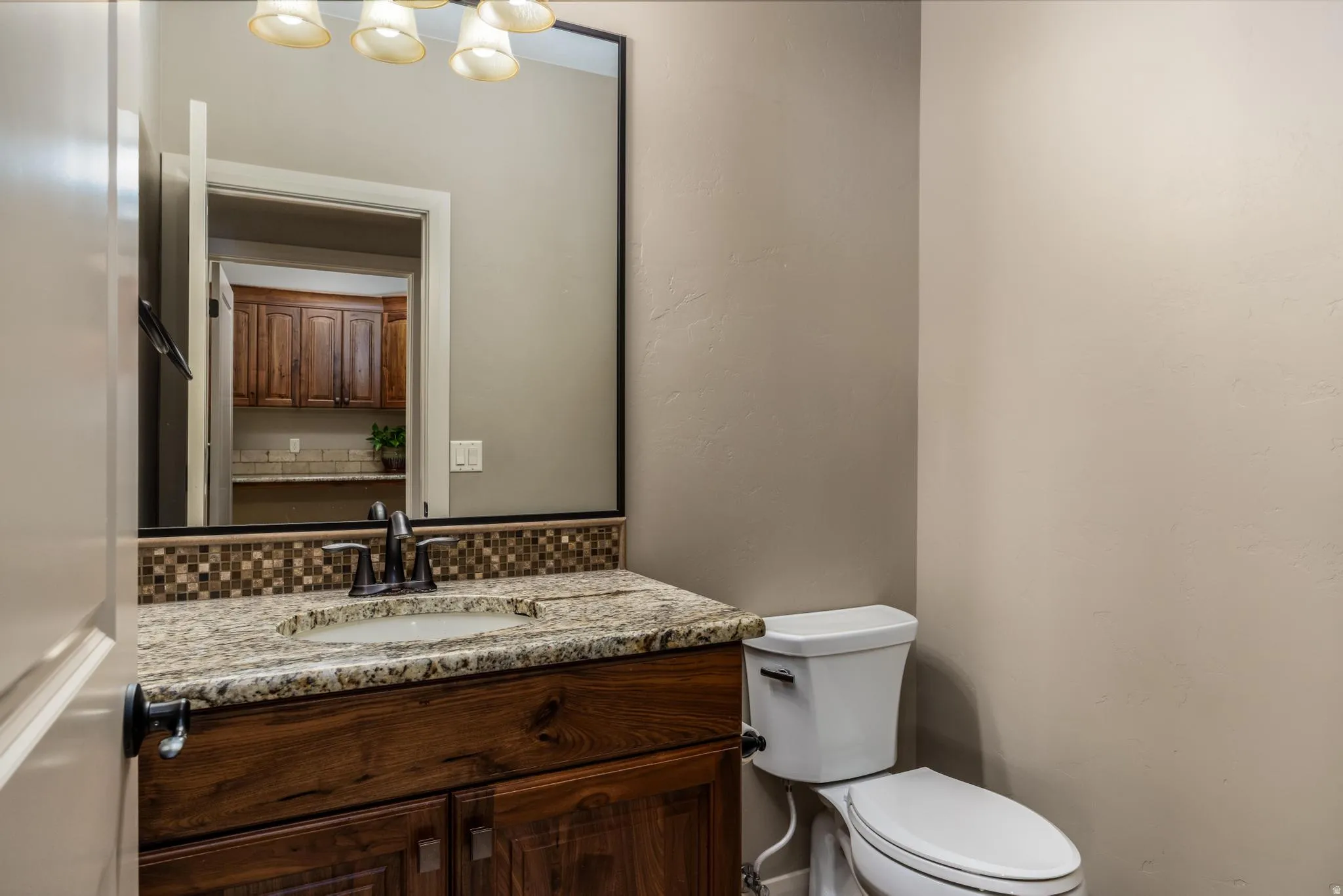 Bathroom vanity featuring a granite countertop, integrated sink, and dark wood-finish cabinetry