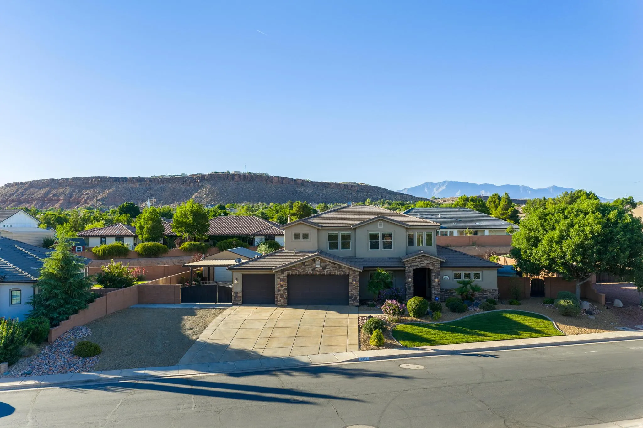 Two-story residence featuring a stucco exterior with stone accents, an attached two-car garage, and a concrete driveway