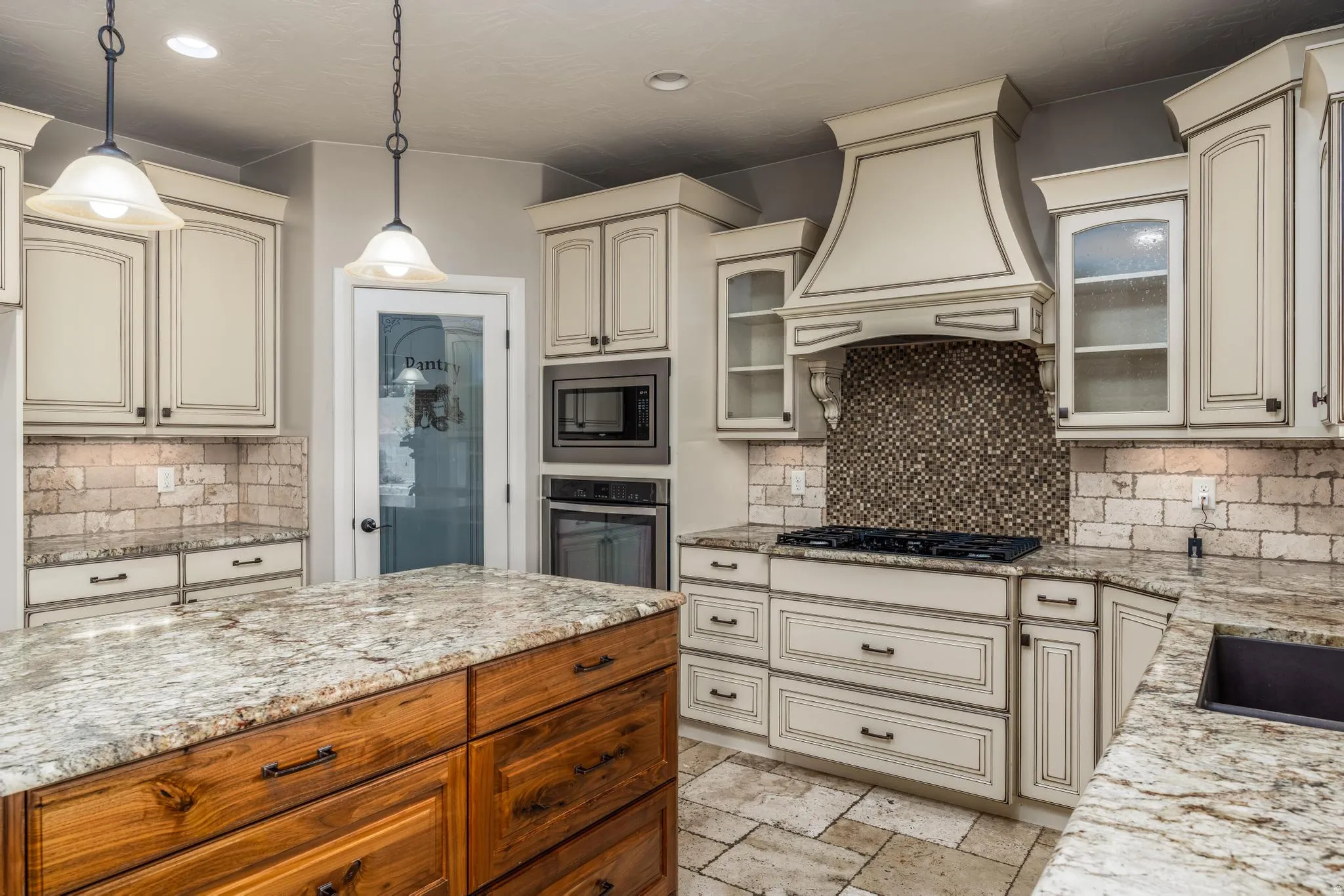 Gourmet kitchen featuring a central island with natural wood cabinetry and a stone countertop