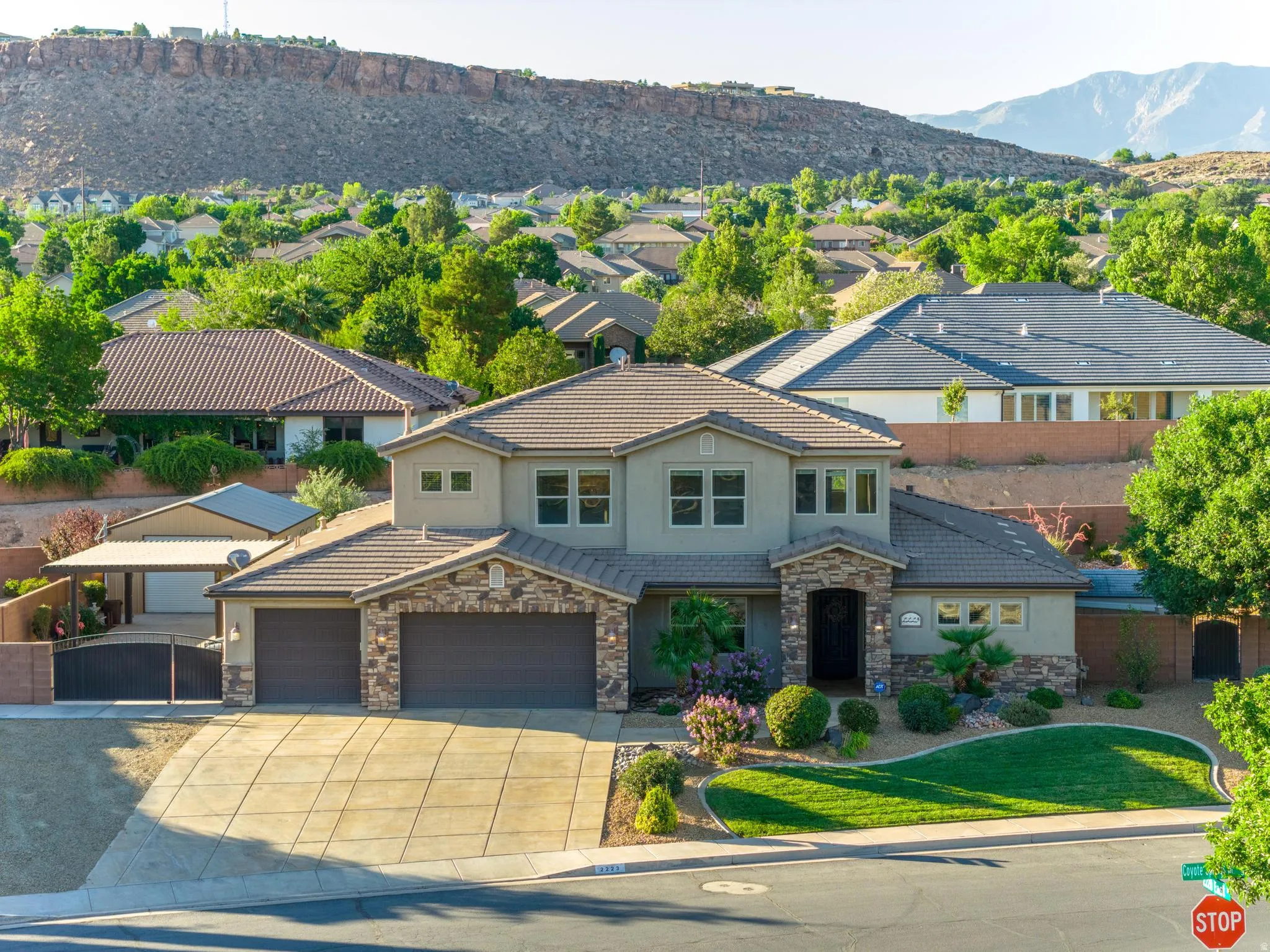 Two-story residence featuring a stucco and stone veneer exterior, a concrete tile roof, and an attached three-car garage
