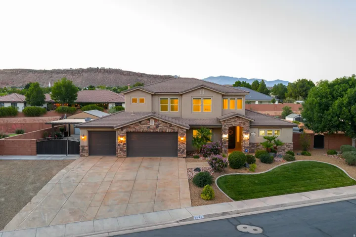 Stucco residence featuring a stone facade and a two-car garage