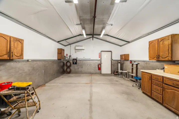 Spacious interior structure featuring a vaulted ceiling with white fabric lining, fluorescent lighting fixtures, and exposed metal framing