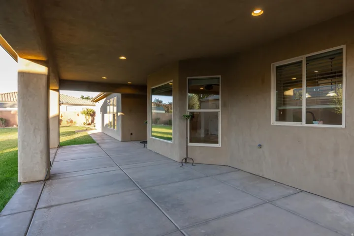 Expansive covered patio featuring concrete flooring, recessed lighting, and stucco columns