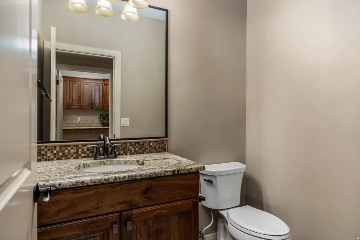 Bathroom vanity featuring a granite countertop, integrated sink, and dark wood-finish cabinetry