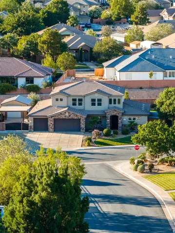 Two-story residence featuring a stone and stucco exterior, multi-pane windows, and a tiled roof