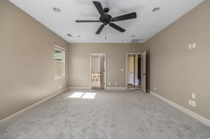 Spacious room featuring neutral carpeting, a ceiling fan, recessed lighting, and a window with blinds
