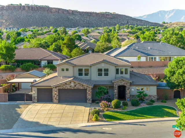 Two-story residence featuring a stucco and stone veneer exterior, a concrete tile roof, and an attached three-car garage