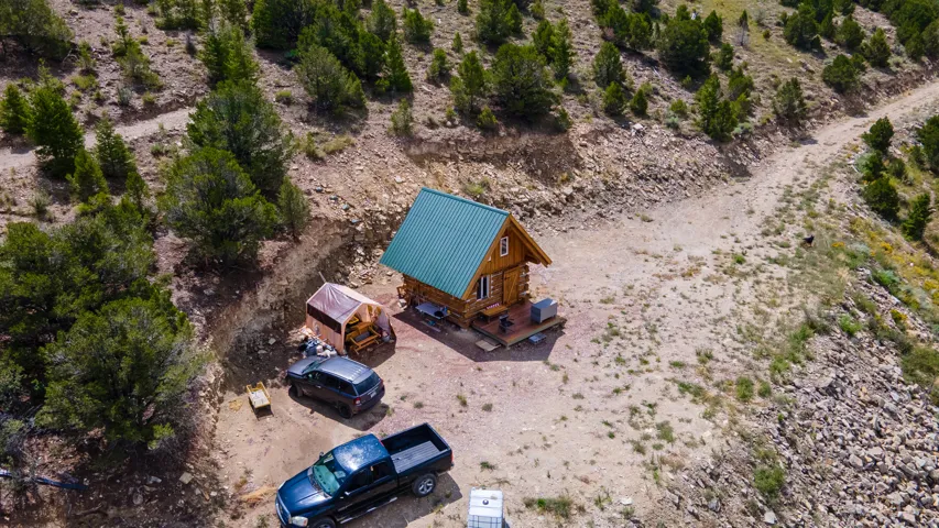 Log cabin residence featuring a green metal roof and a wooden deck